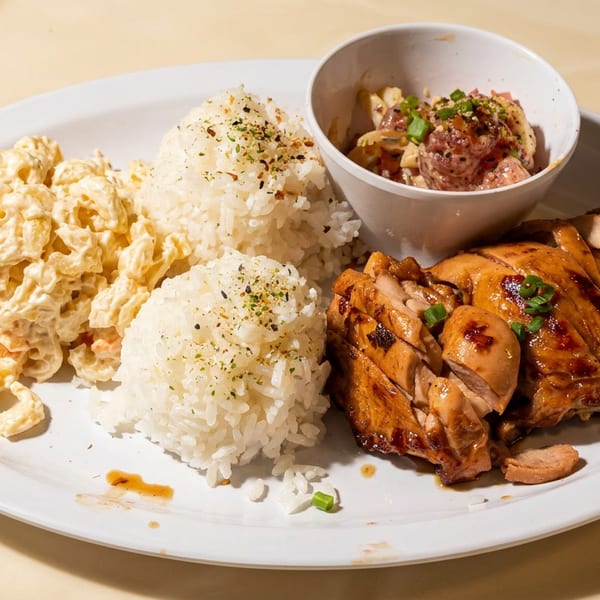 A Hawaiian plate lunch with grilled chicken, two scoops of rice, macaroni salad, and poke.
